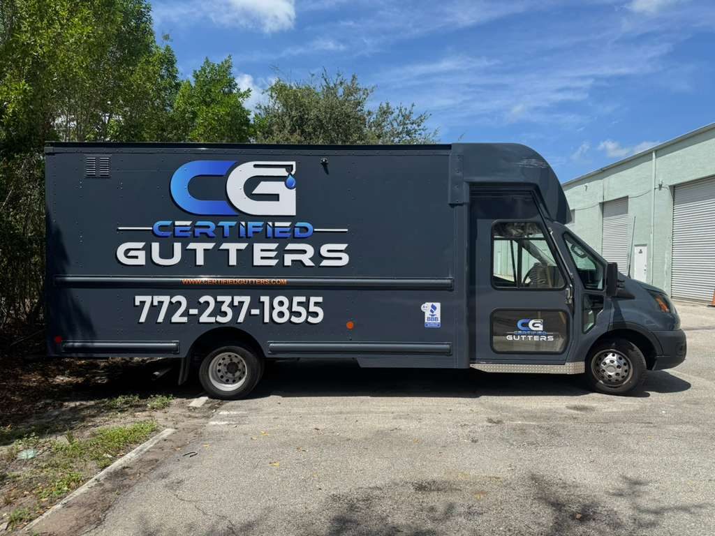 Side profile of the dark gray Certified Gutters branded box truck — full vehicle wrap with CG logo, phone number, website, and BBB badge visible