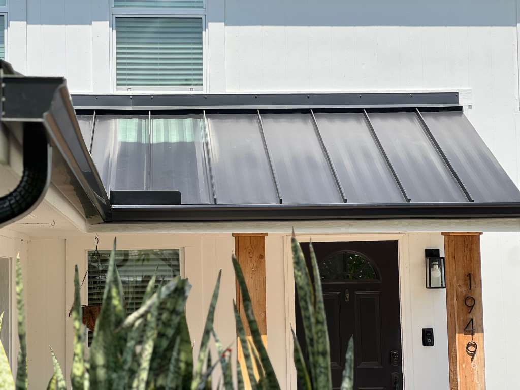 Dark-gray gutters along the porch of a Florida home with a standing-seam metal roof
